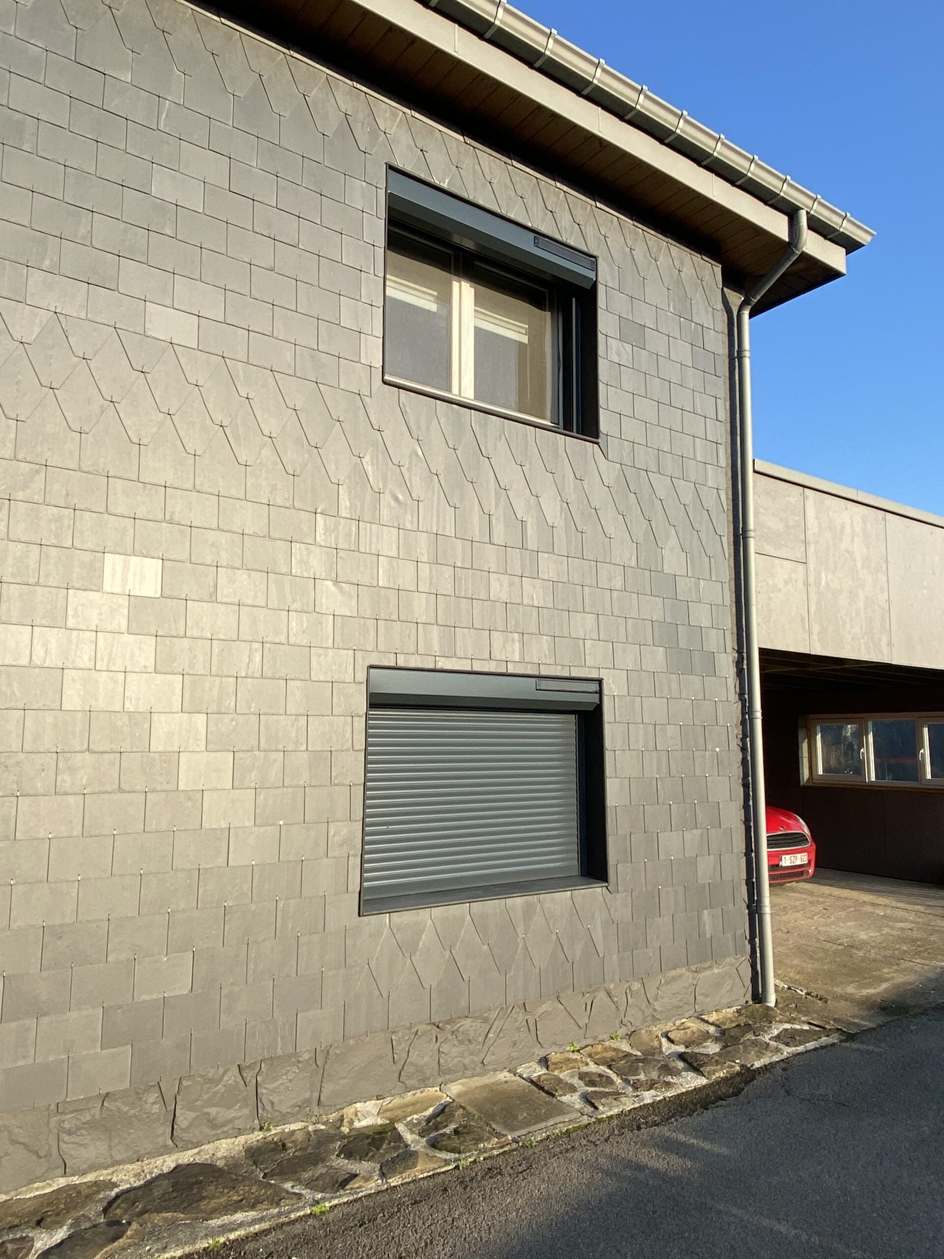 volets gris sur porte et fenêtres de façade en brique et pierre grise